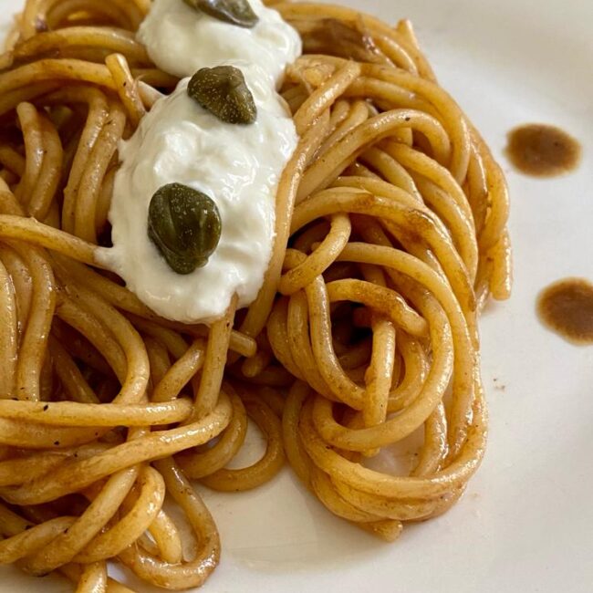 spaghettoni aglio nero aggiughe e stracciatella di burrata